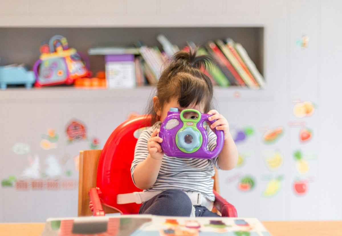 Personalized kids and baby gifts: a child playing with a toy camera