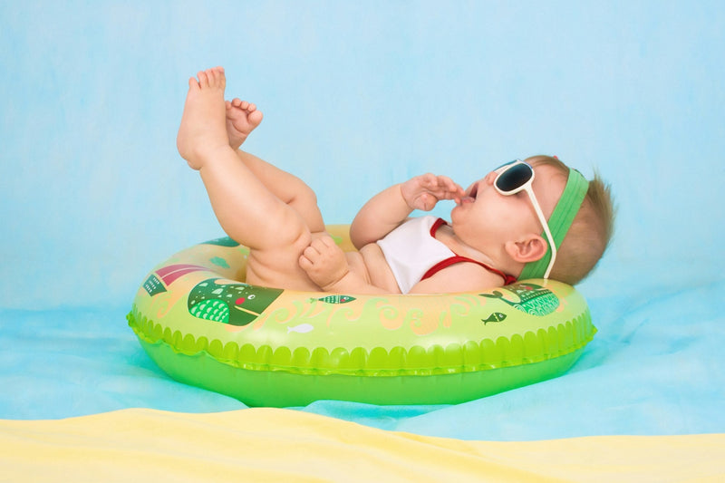 A baby with sunglasses on a pool float, personalized baby gifts